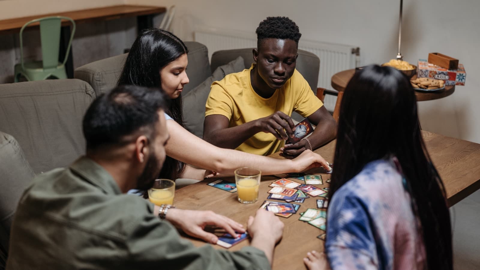 A group of friends trading and playing card games together at a table